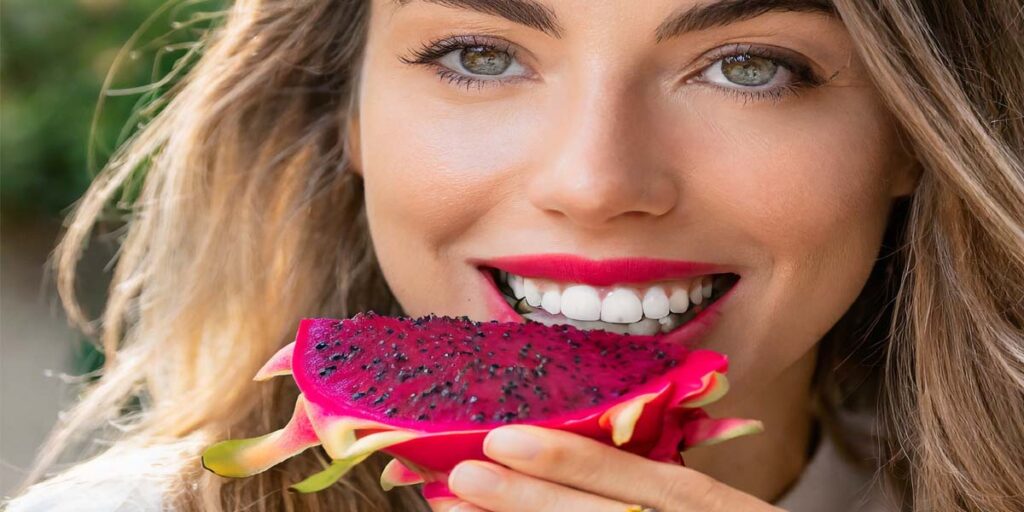 A girl with a piece of dragon fruit