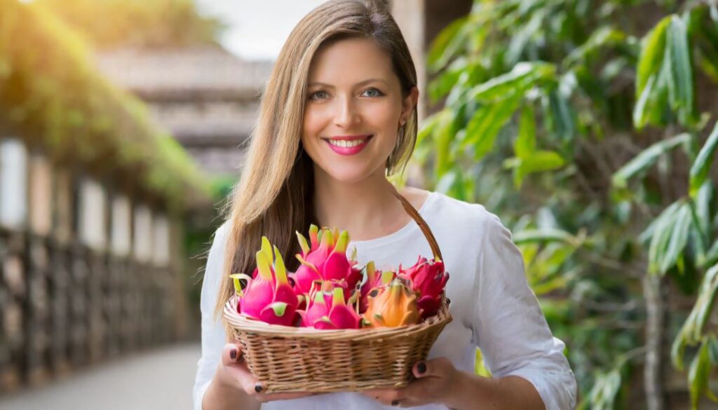 A young women with a basket full of dragon fruits